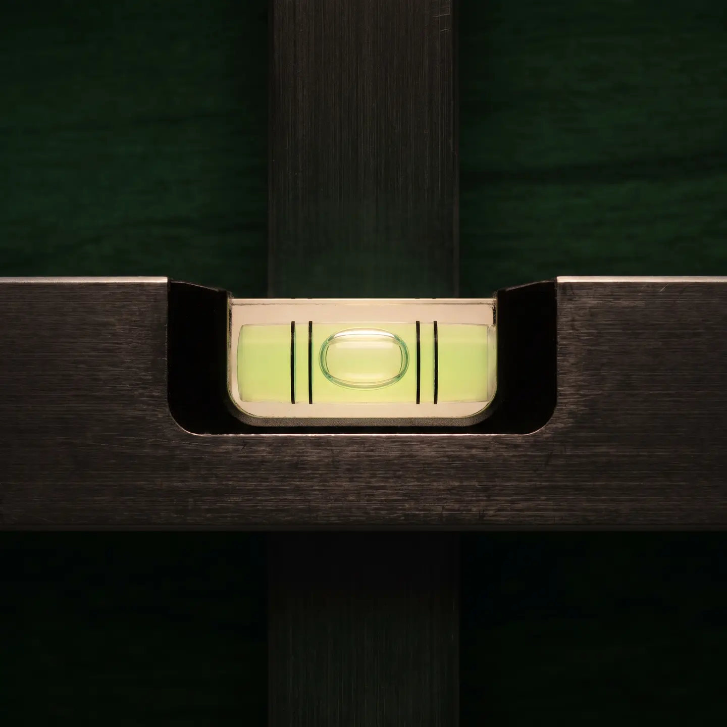 Macro of a spirit level vial with its bubble resting dead centre between the lines